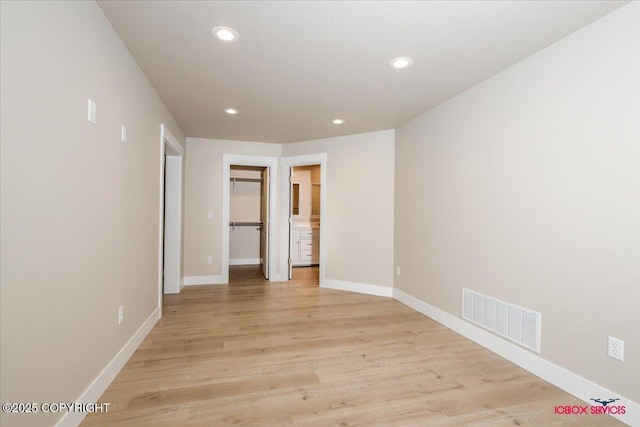 9089 E Spring Creek Cir, Palmer, AK 99645 - unfurnished bedroom featuring recessed lighting, baseboards, light wood-type flooring, a walk in closet, and a closet