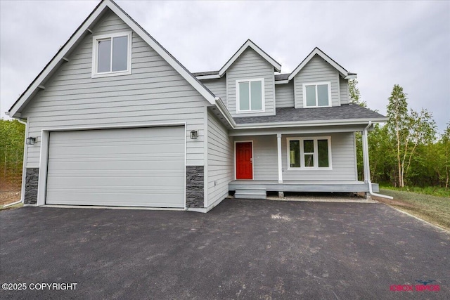 9089 E Spring Creek Cir, Palmer, AK 99645 - view of front of house featuring driveway, covered porch, and stone siding
