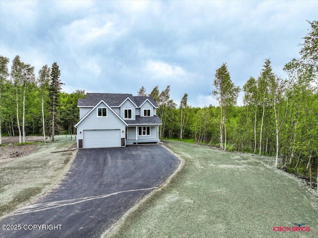 9089 E Spring Creek Cir, Palmer, AK 99645 - traditional home with driveway, a forest view, a garage, and roof with shingles