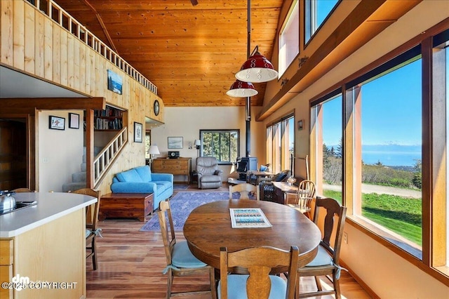 5301 N Glacier View Ct, Homer, AK 99603 - dining room with wooden ceiling, wood finished floors, a wood stove, and stairway
