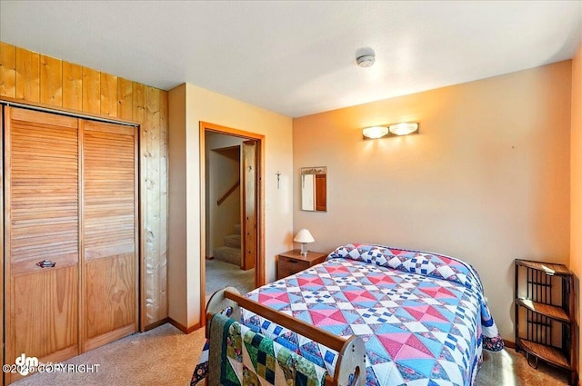 5301 N Glacier View Ct, Homer, AK 99603 - bedroom featuring light carpet, wood walls, and a closet