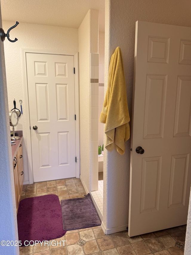 17110 E Kathy Cir, Palmer, AK 99645 - bathroom featuring vanity, a textured wall, and stone finish flooring