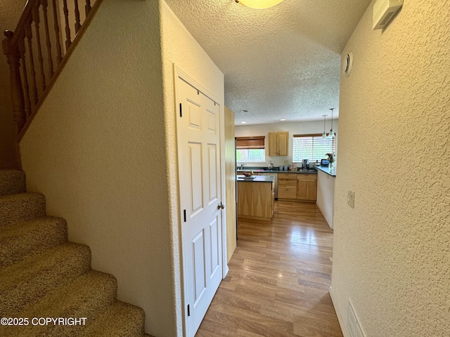 17110 E Kathy Cir, Palmer, AK 99645 - corridor featuring a textured wall, stairway, a textured ceiling, and light wood finished floors