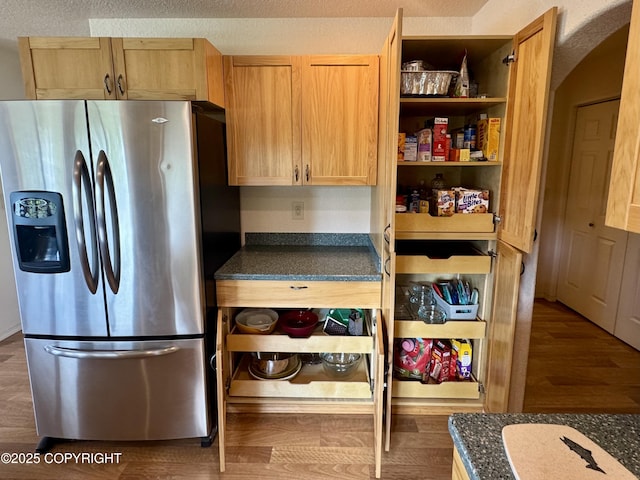 17110 E Kathy Cir, Palmer, AK 99645 - kitchen with stainless steel fridge, dark countertops, arched walkways, and dark wood-type flooring