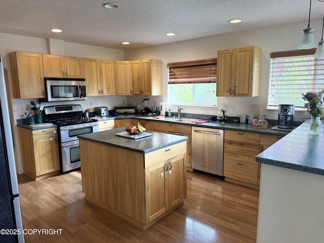 17110 E Kathy Cir, Palmer, AK 99645 - kitchen with appliances with stainless steel finishes, dark countertops, a textured ceiling, a sink, and wood finished floors