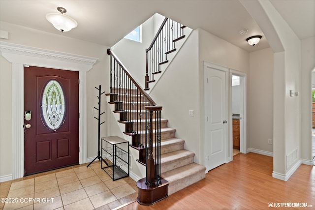 1675 E Pintail Dr, Wasilla, AK 99645 - foyer featuring arched walkways, stairs, light wood-type flooring, and baseboards