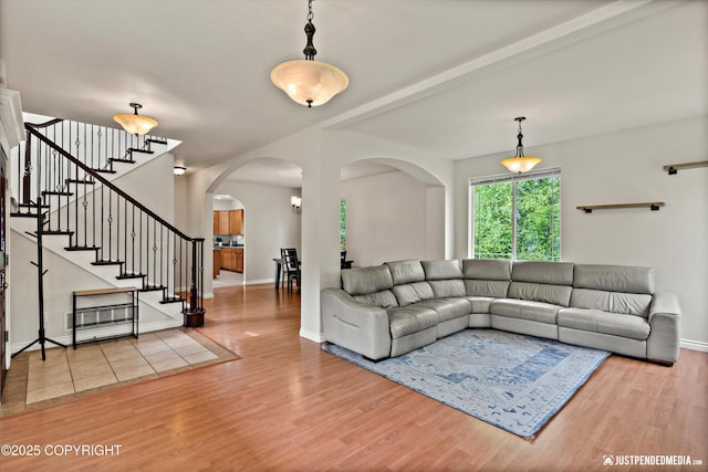 1675 E Pintail Dr, Wasilla, AK 99645 - living area with arched walkways, wood finished floors, stairs, and baseboards