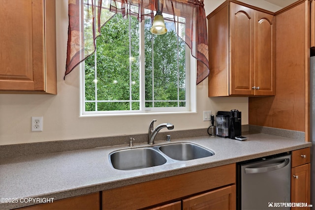 1675 E Pintail Dr, Wasilla, AK 99645 - kitchen with stainless steel dishwasher, a sink, light countertops, and brown cabinetry