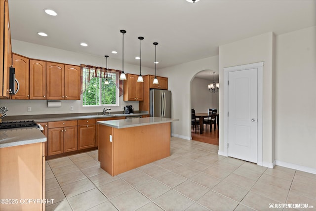 1675 E Pintail Dr, Wasilla, AK 99645 - kitchen with stainless steel appliances, arched walkways, a kitchen island, a sink, and light tile patterned floors