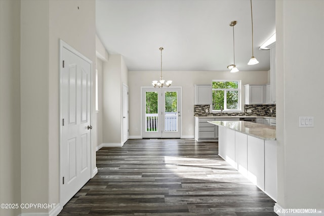 1130 W Granville St, Palmer, AK 99645 - kitchen featuring dark wood-style floors, backsplash, a chandelier, white cabinetry, and hanging light fixtures
