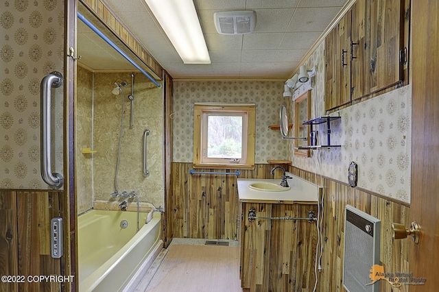8301 W Lost Valley Rd, Wasilla, AK 99623 - full bath featuring wallpapered walls, wainscoting, heating unit, shower / washtub combination, and wood finished floors