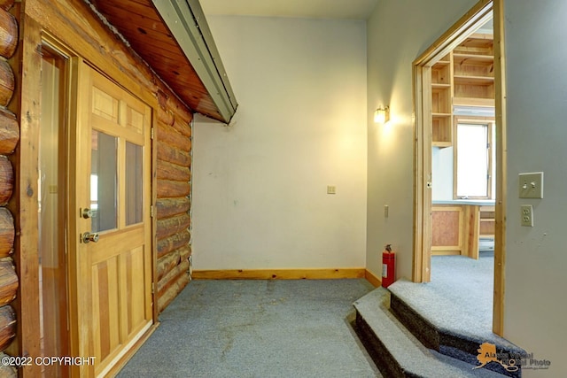 8301 W Lost Valley Rd, Wasilla, AK 99623 - hall featuring log walls, carpet floors, and baseboards