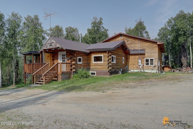 8301 W Lost Valley Rd, Wasilla, AK 99623 - log cabin featuring metal roof, log exterior, and a porch