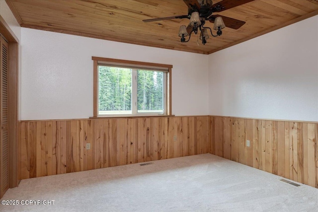 3432 Conifer Dr, North Pole, AK 99705 - carpeted spare room featuring a wainscoted wall, wood walls, wooden ceiling, and ceiling fan