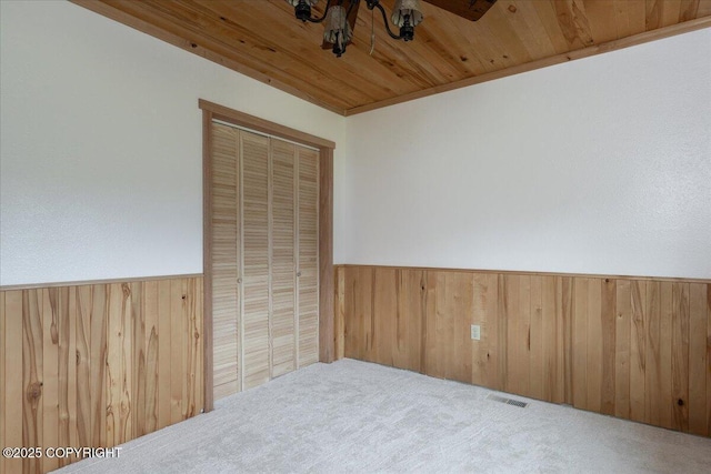 3432 Conifer Dr, North Pole, AK 99705 - unfurnished room featuring wooden walls, wainscoting, carpet flooring, and wood ceiling