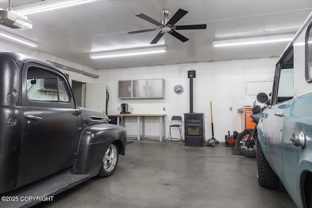 3432 Conifer Dr, North Pole, AK 99705 - garage with a garage door opener, a ceiling fan, and a wood stove