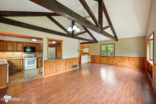 650 N Esty Dr, Palmer, AK 99645 - kitchen with white appliances, wainscoting, dark wood finished floors, brown cabinets, and open floor plan