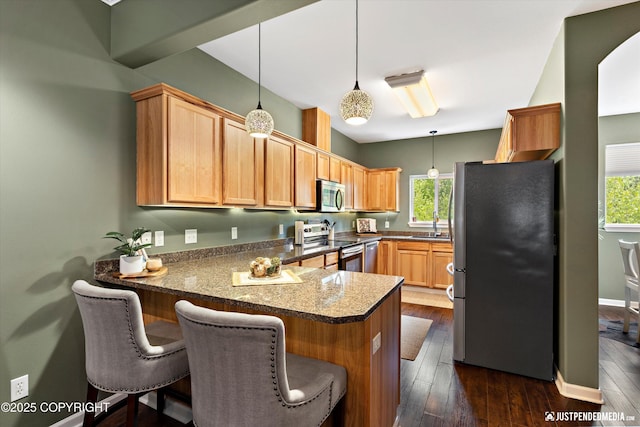 12621 Bona Kim Loop # 4, Anchorage, AK 99515 - kitchen with stainless steel appliances, a peninsula, healthy amount of natural light, and hanging light fixtures