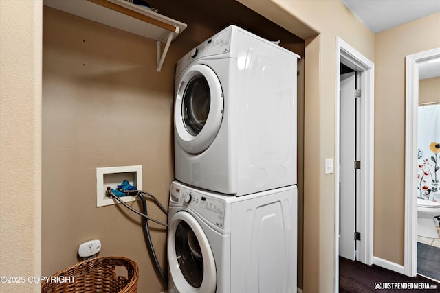 12621 Bona Kim Loop # 4, Anchorage, AK 99515 - laundry area featuring stacked washing machine and dryer, dark colored carpet, and baseboards