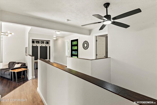 1551 S Oat St, Wasilla, AK 99654 - hall featuring an upstairs landing, a textured ceiling, wood finished floors, and baseboards