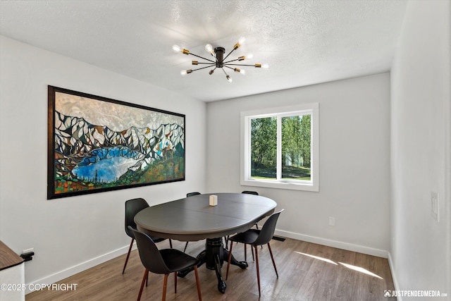 1551 S Oat St, Wasilla, AK 99654 - dining room featuring a chandelier, wood finished floors, baseboards, and a textured ceiling