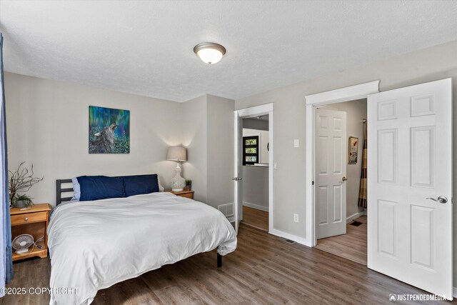 1551 S Oat St, Wasilla, AK 99654 - bedroom with wood finished floors, a textured ceiling, and baseboards