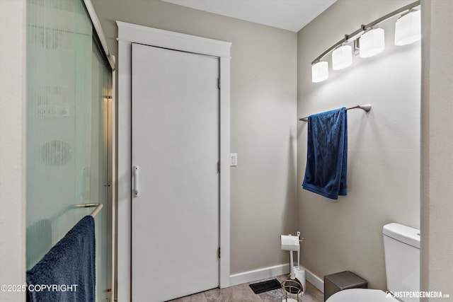 1551 S Oat St, Wasilla, AK 99654 - bathroom with toilet, a shower with shower door, and baseboards