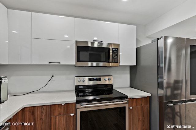 1551 S Oat St, Wasilla, AK 99654 - kitchen with appliances with stainless steel finishes, modern cabinets, and white cabinetry