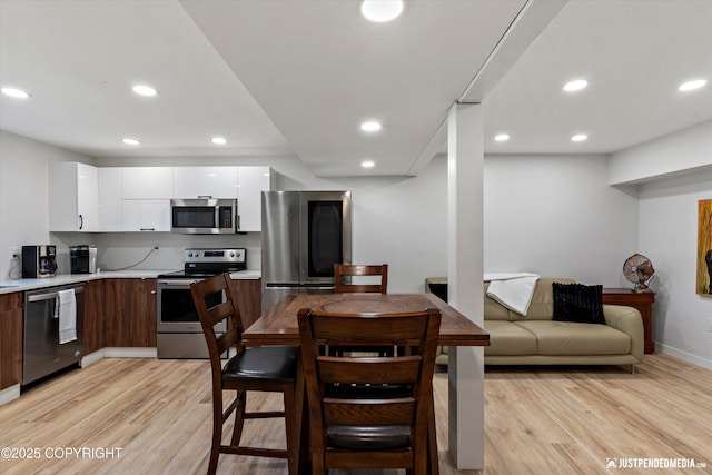 1551 S Oat St, Wasilla, AK 99654 - kitchen featuring appliances with stainless steel finishes, modern cabinets, light countertops, light wood-style floors, and white cabinets
