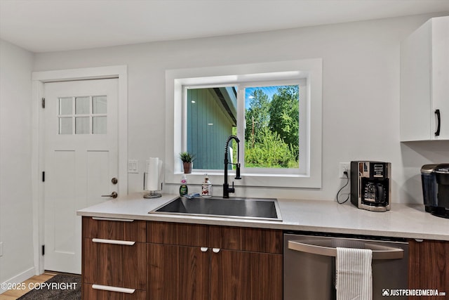 1551 S Oat St, Wasilla, AK 99654 - kitchen featuring dishwasher, a sink, light countertops, and wood finished floors