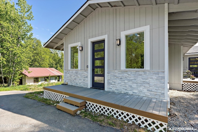 1551 S Oat St, Wasilla, AK 99654 - view of exterior entry featuring stone siding and a wooden deck