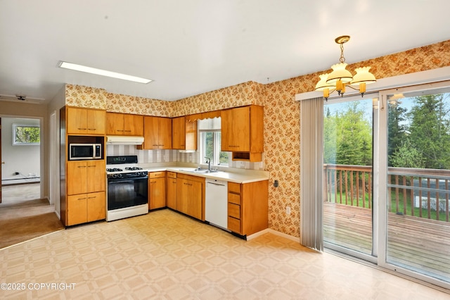 7101 Omalley Rd, Anchorage, AK 99507 - kitchen featuring white appliances, under cabinet range hood, light flooring, wallpapered walls, and healthy amount of natural light