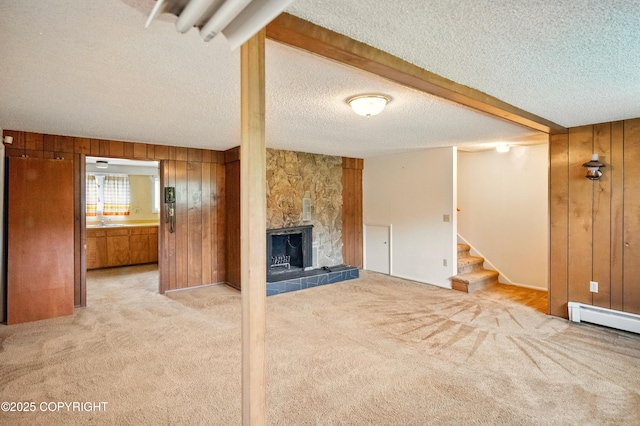 7101 Omalley Rd, Anchorage, AK 99507 - unfurnished living room with wood walls, a textured ceiling, stairway, light carpet, and baseboard heating