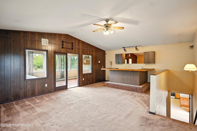 7101 Omalley Rd, Anchorage, AK 99507 - unfurnished living room featuring lofted ceiling, carpet flooring, wood walls, and ceiling fan