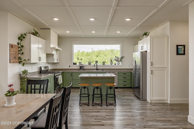 5233 W Jaxton Cir, Wasilla, AK 99623 - kitchen featuring green cabinetry, appliances with stainless steel finishes, recessed lighting, a sink, and wood finished floors