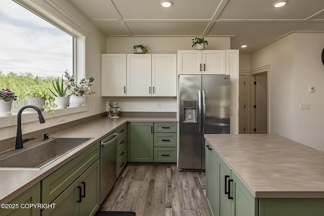 5233 W Jaxton Cir, Wasilla, AK 99623 - kitchen with green cabinets, stainless steel appliances, a sink, white cabinetry, and recessed lighting