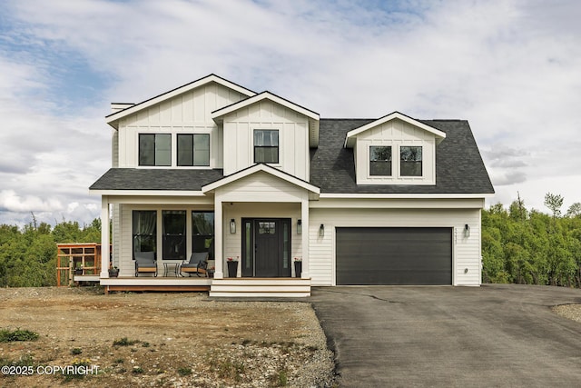5233 W Jaxton Cir, Wasilla, AK 99623 - view of front of home featuring an attached garage, covered porch, driveway, a shingled roof, and board and batten siding