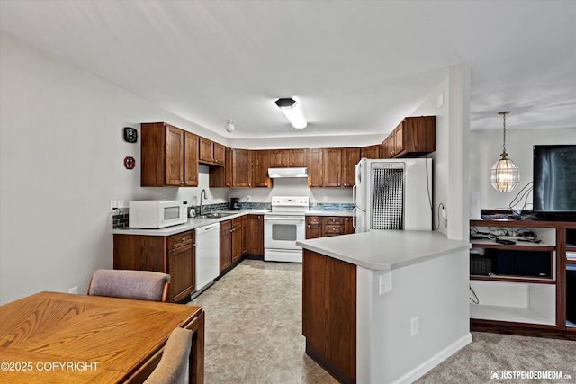 3529 W 41st Ave, Anchorage, AK 99517 - kitchen with white appliances, light countertops, a sink, a peninsula, and under cabinet range hood