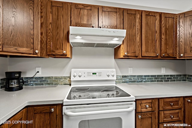3529 W 41st Ave, Anchorage, AK 99517 - kitchen featuring white electric range, exhaust hood, light countertops, and brown cabinets