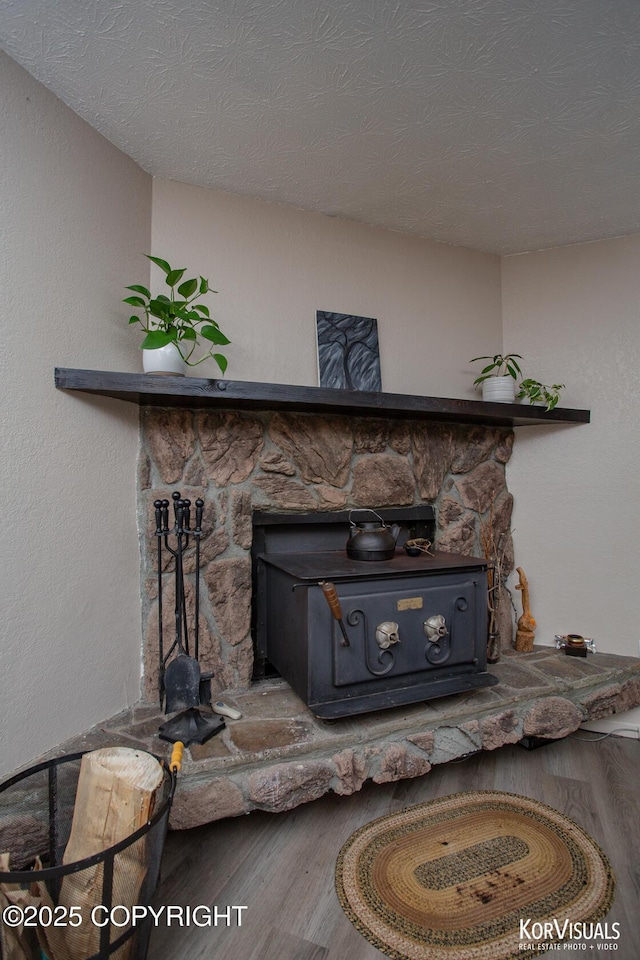 767 N Yakima St, Wasilla, AK 99654 - detailed view of a wood stove, wood finished floors, and a textured ceiling