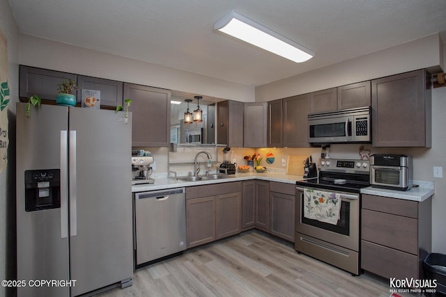 767 N Yakima St, Wasilla, AK 99654 - kitchen with appliances with stainless steel finishes, light countertops, light wood finished floors, and dark brown cabinets