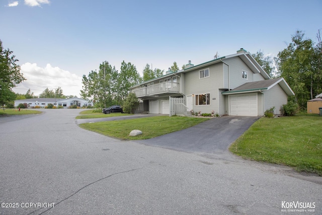 767 N Yakima St, Wasilla, AK 99654 - view of front of home featuring asphalt driveway, a balcony, a front lawn, and a chimney