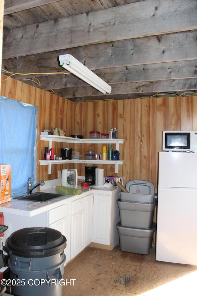 63760 Elizabeth Ave, Ninilchik, AK 99639 - kitchen featuring white appliances, a sink, wood walls, open shelves, and white cabinetry