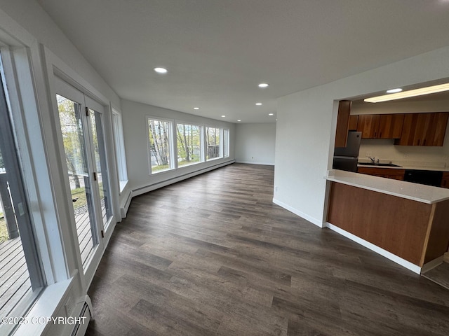 1430 Bridgeway St # 3, Anchorage, AK 99501 - unfurnished living room with baseboard heating, recessed lighting, a sink, dark wood finished floors, and baseboards