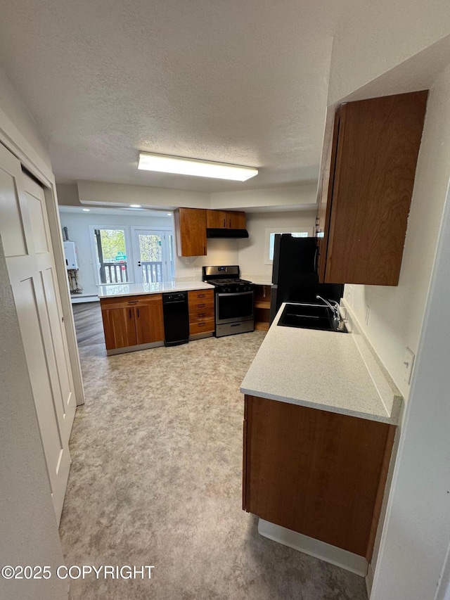 1430 Bridgeway St # 3, Anchorage, AK 99501 - kitchen with stainless steel gas range oven, a sink, brown cabinets, light countertops, and freestanding refrigerator