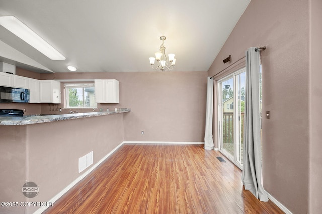 3933 Sycamore Loop, Anchorage, AK 99504 - kitchen featuring black microwave, vaulted ceiling, white cabinetry, a chandelier, and light wood-style floors