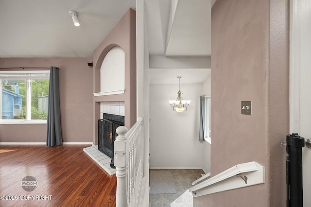 3933 Sycamore Loop, Anchorage, AK 99504 - living area featuring a fireplace, wood finished floors, a chandelier, baseboards, and vaulted ceiling