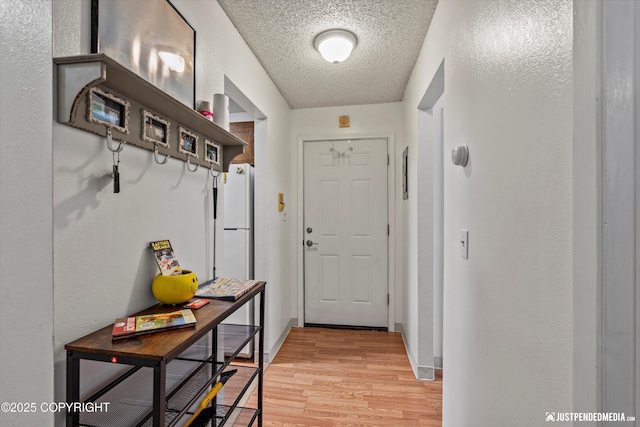 4433 San Ernesto Ave # 104, Anchorage, AK 99508 - doorway to outside with a textured ceiling and light wood-style floors