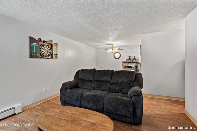 4433 San Ernesto Ave # 104, Anchorage, AK 99508 - living room featuring baseboard heating, a ceiling fan, wood finished floors, a textured ceiling, and baseboards