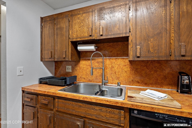 4433 San Ernesto Ave # 104, Anchorage, AK 99508 - kitchen featuring a sink, black dishwasher, tasteful backsplash, and light countertops